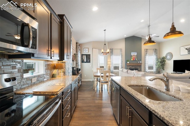 kitchen with pendant lighting, dark brown cabinetry, stainless steel appliances, and sink