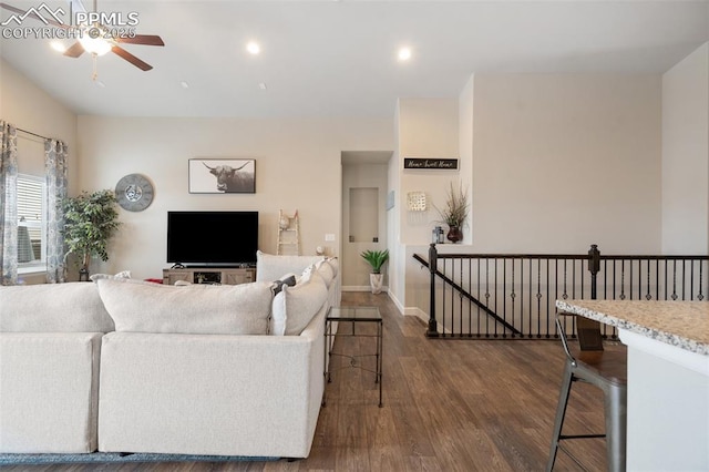 living room featuring dark wood-type flooring and ceiling fan