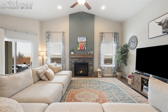 living room featuring vaulted ceiling, plenty of natural light, ceiling fan, and a fireplace