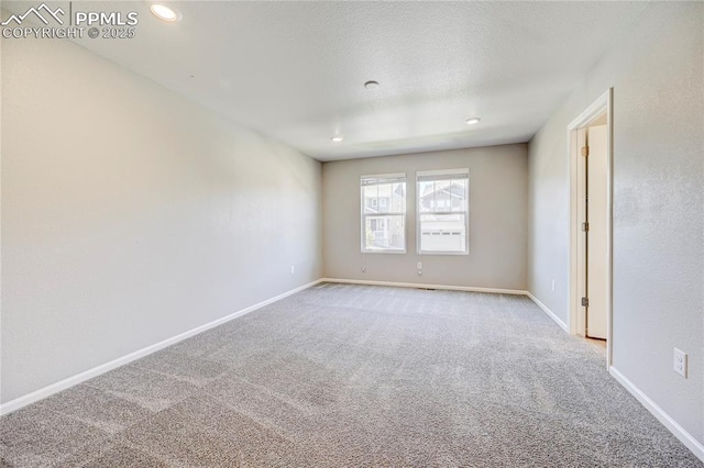 carpeted empty room featuring a textured ceiling