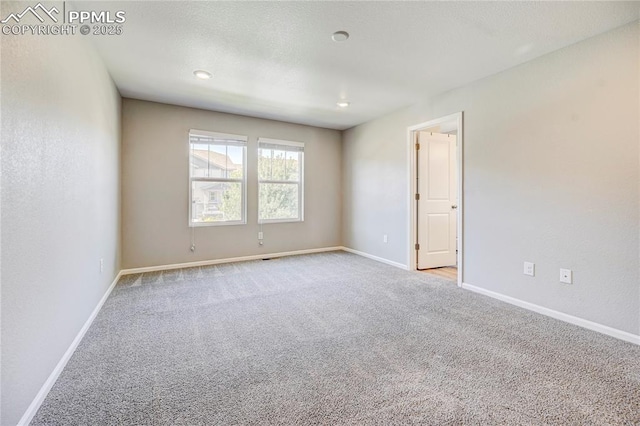 spare room featuring light colored carpet