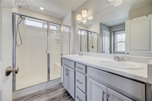 bathroom with hardwood / wood-style flooring, vanity, and walk in shower