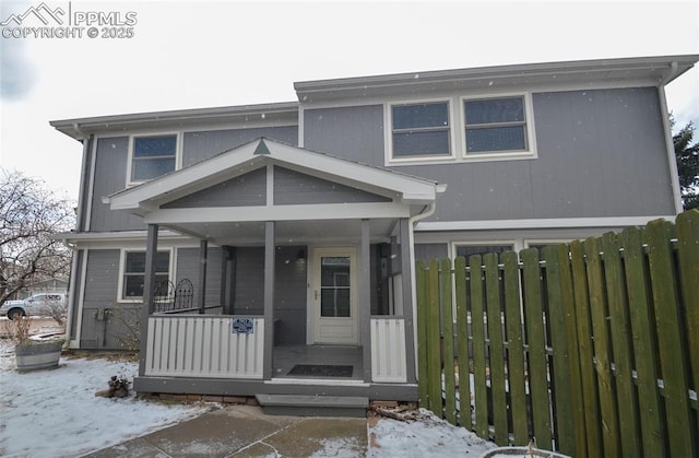 view of front of home with covered porch and fence