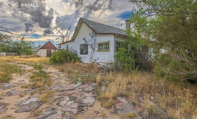 property exterior at dusk featuring a chimney