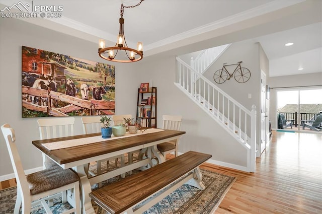 dining area featuring crown molding, a notable chandelier, and light hardwood / wood-style floors