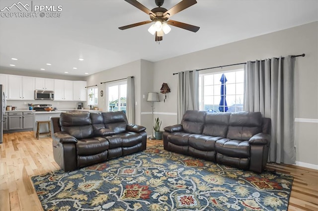 living room featuring ceiling fan and light wood-type flooring