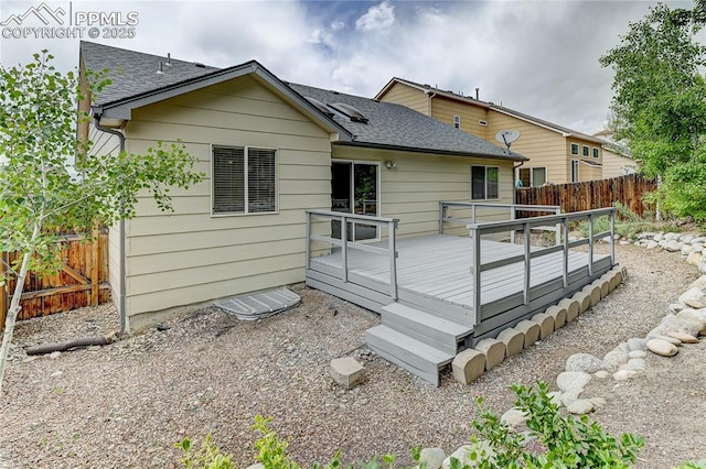 rear view of property featuring a wooden deck