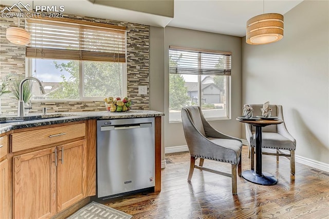 kitchen featuring decorative light fixtures, sink, decorative backsplash, hardwood / wood-style flooring, and stainless steel dishwasher