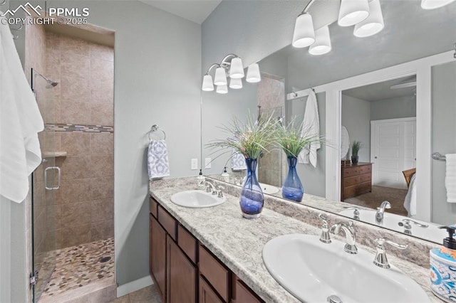 bathroom featuring double vanity, a sink, and a shower stall