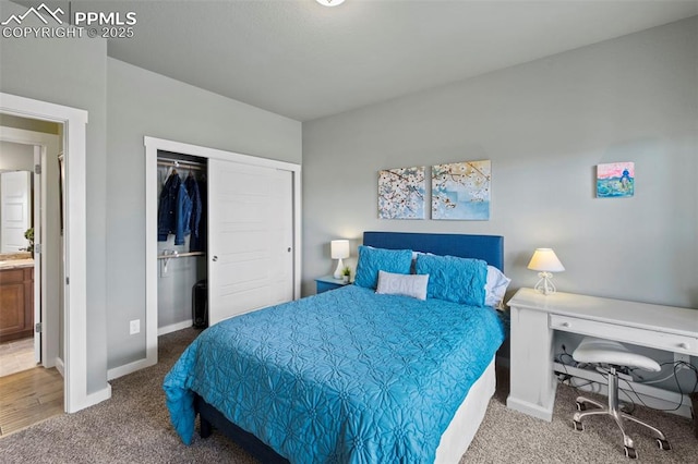 carpeted bedroom with a closet, connected bathroom, and baseboards