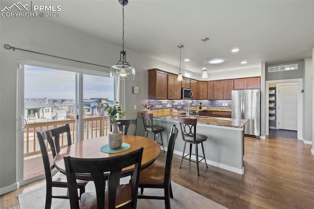 dining space featuring recessed lighting, wood finished floors, and baseboards