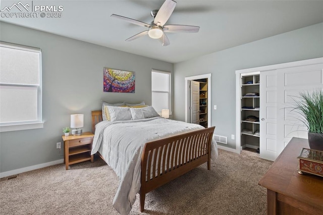 carpeted bedroom with a ceiling fan, visible vents, and baseboards