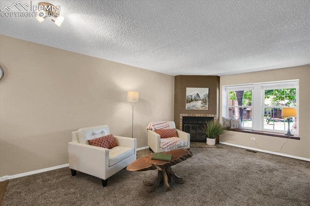 living area with dark colored carpet, a brick fireplace, and a textured ceiling