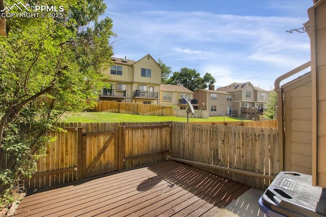 wooden deck featuring a lawn