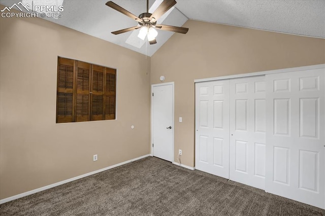 unfurnished bedroom with high vaulted ceiling, a closet, ceiling fan, and dark colored carpet