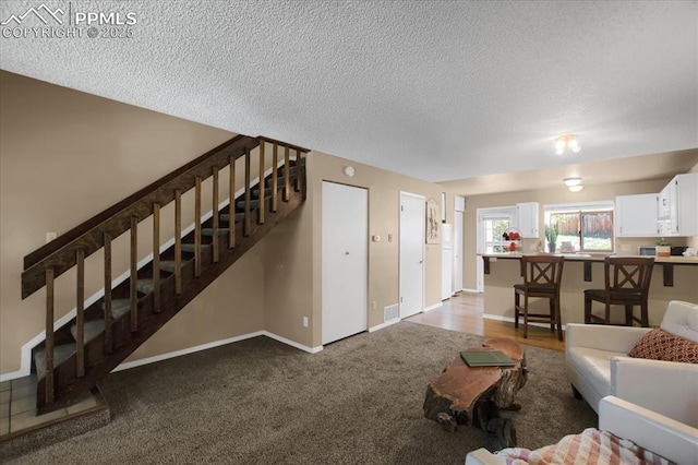 unfurnished living room with light carpet and a textured ceiling