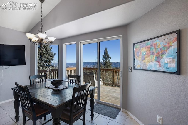 dining space featuring a notable chandelier, light tile patterned floors, lofted ceiling, a mountain view, and baseboards