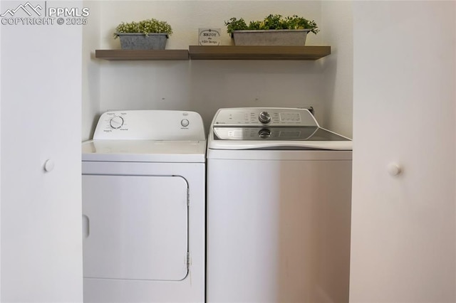 clothes washing area with laundry area and washer and clothes dryer