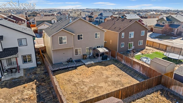 back of property featuring a trampoline and a patio