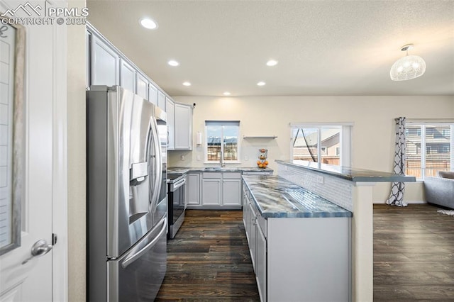 kitchen with white cabinets, hanging light fixtures, a healthy amount of sunlight, and appliances with stainless steel finishes