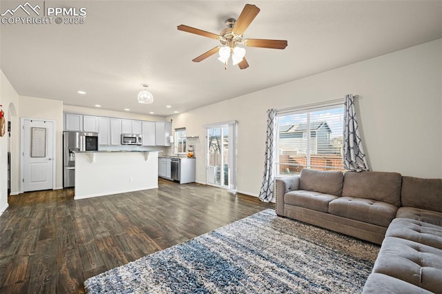 living room featuring dark hardwood / wood-style flooring and ceiling fan