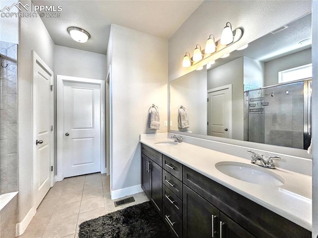 bathroom featuring tile patterned flooring, vanity, and walk in shower