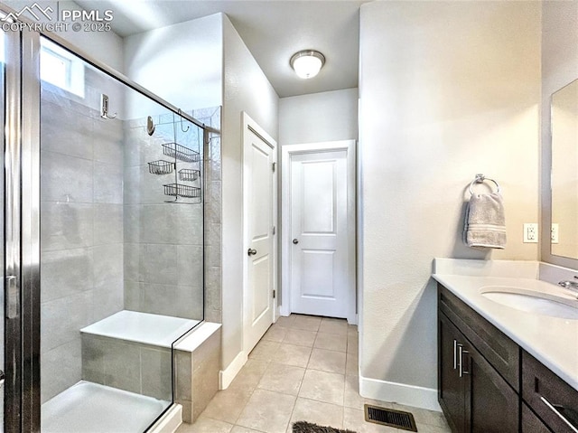 bathroom featuring a shower with door, vanity, and tile patterned flooring