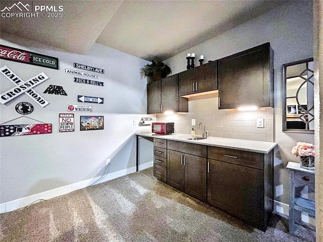 kitchen featuring sink, decorative backsplash, and dark brown cabinets