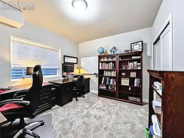 carpeted office space featuring a textured ceiling