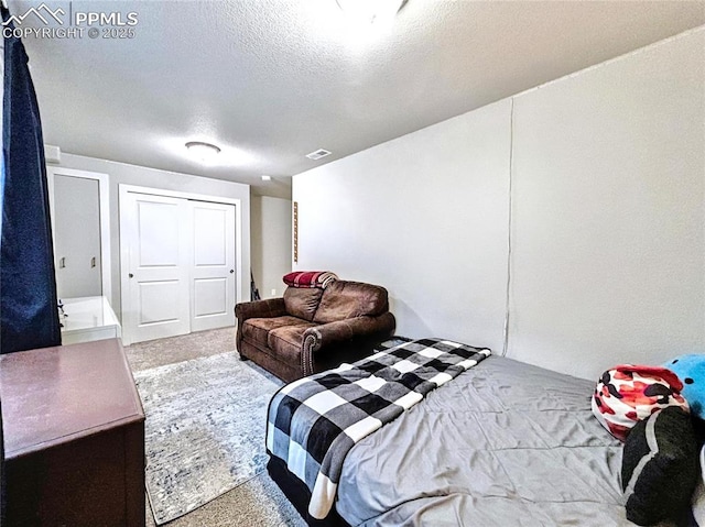 bedroom with carpet floors and a textured ceiling