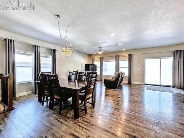 dining room featuring ceiling fan with notable chandelier, hardwood / wood-style floors, and a textured ceiling