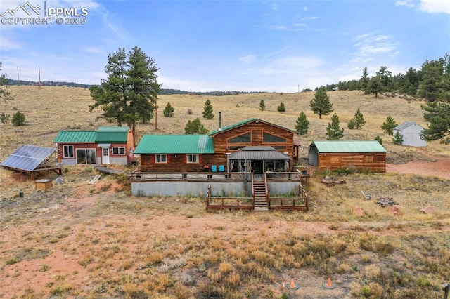 back of property featuring a rural view and a shed