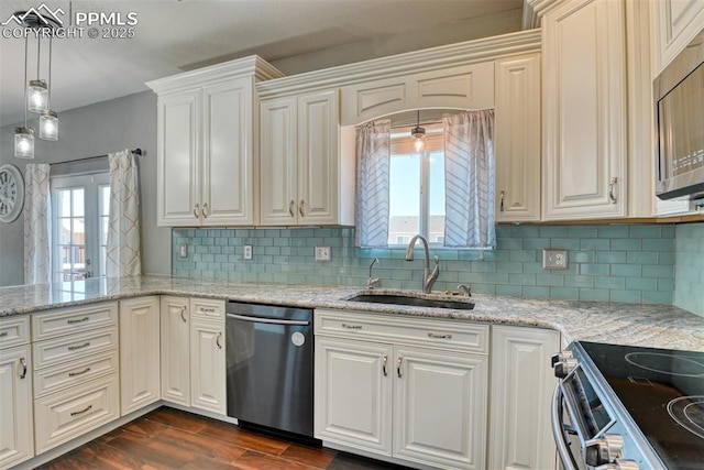 kitchen featuring sink, appliances with stainless steel finishes, hanging light fixtures, light stone countertops, and dark hardwood / wood-style flooring