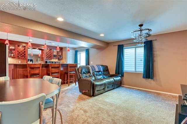 living room featuring indoor bar, plenty of natural light, carpet floors, and a textured ceiling