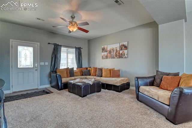 living room with ceiling fan, carpet, and a textured ceiling