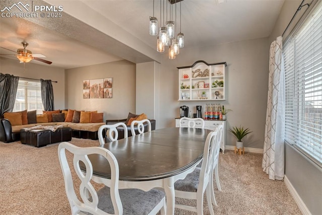 dining space with light carpet and ceiling fan with notable chandelier