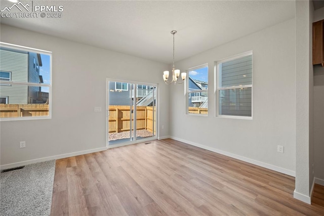 unfurnished dining area featuring hardwood / wood-style flooring and a chandelier