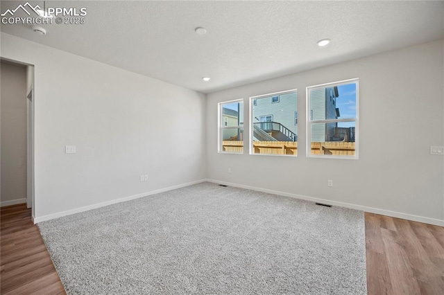 spare room featuring a textured ceiling and light wood-type flooring