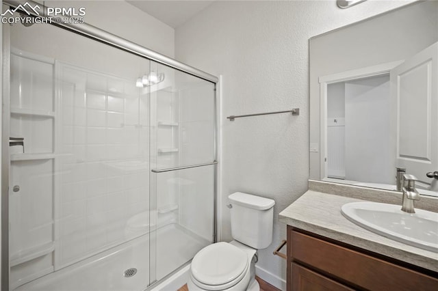 bathroom featuring an enclosed shower, vanity, and toilet