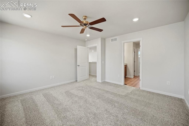 unfurnished bedroom featuring ceiling fan, connected bathroom, light carpet, and a spacious closet