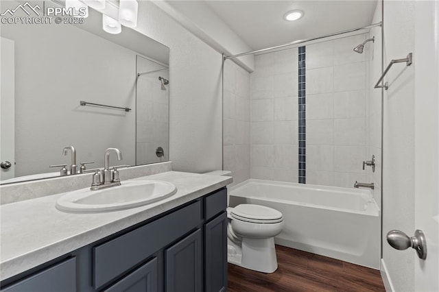 full bathroom featuring tiled shower / bath combo, wood-type flooring, vanity, and toilet