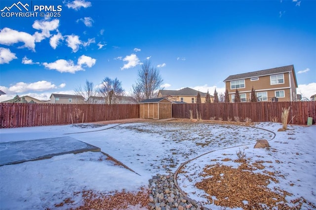 snowy yard with a fenced backyard