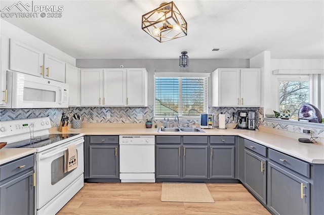 kitchen with gray cabinetry, white appliances, and white cabinetry