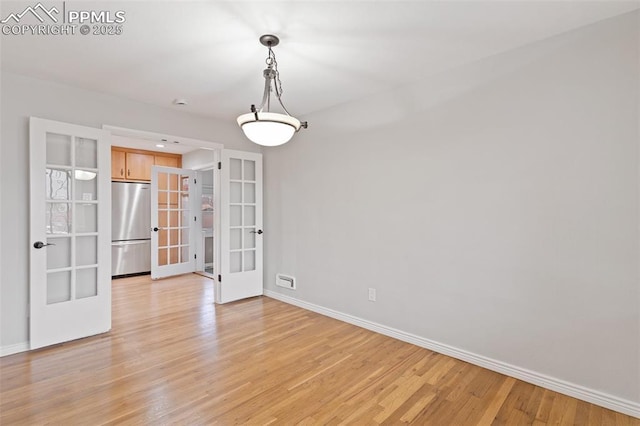 unfurnished dining area with french doors and light wood-type flooring