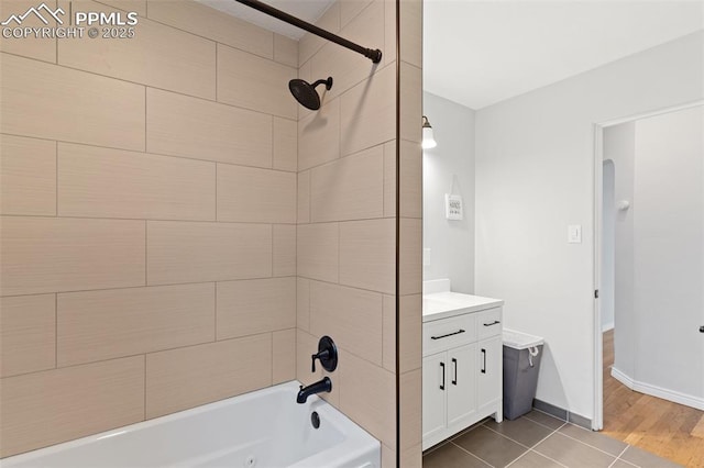 bathroom featuring tiled shower / bath combo, vanity, and tile patterned floors