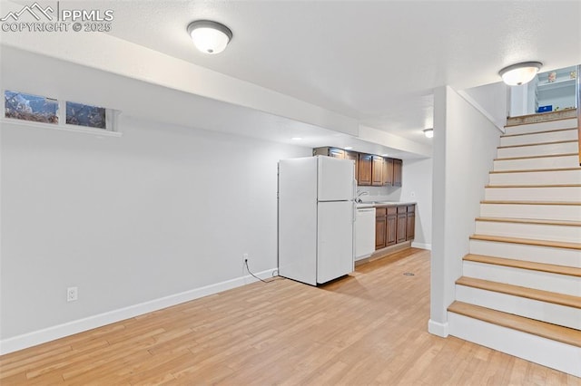 unfurnished living room featuring sink and light hardwood / wood-style flooring