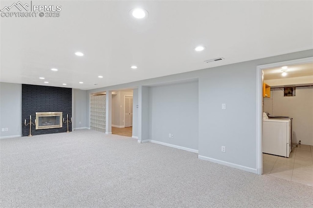 basement with washer / clothes dryer, light carpet, and a fireplace