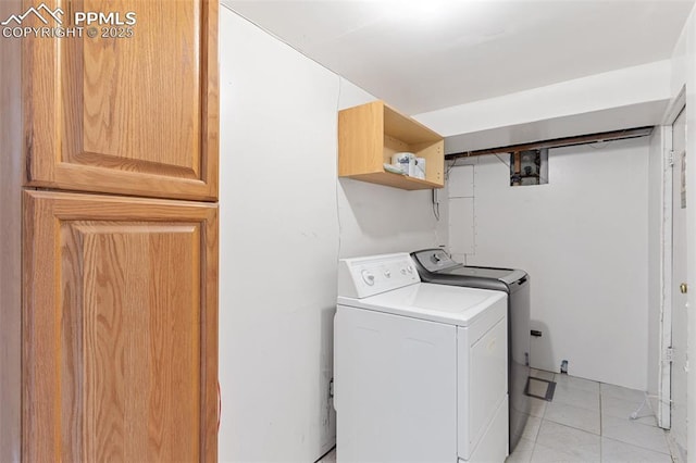 washroom with light tile patterned flooring and washer and dryer