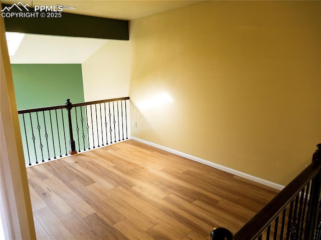 unfurnished room with beamed ceiling, hardwood / wood-style floors, and high vaulted ceiling