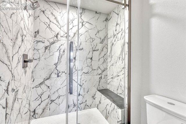 full bathroom with toilet, a marble finish shower, and a textured wall